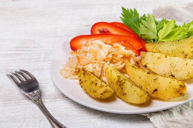 Lahana, tatlı biber ve beyaz bir tabak içinde kereviz ile kızarmış patates.