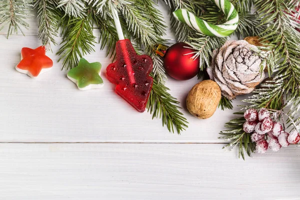 クリスマスのお菓子 軽い木製の背景上のモミの枝 — ストック写真