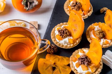 Lor krem, Trabzon hurması ve şeffaf bir fincan çay ile Tartlets.