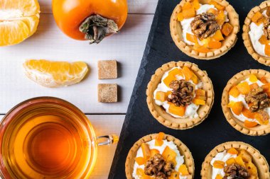 Lor krem, Trabzon hurması ve şeffaf bir fincan çay ile Tartlets.