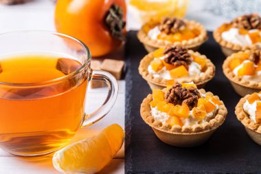 Lor krem, Trabzon hurması ve şeffaf bir fincan çay ile Tartlets.