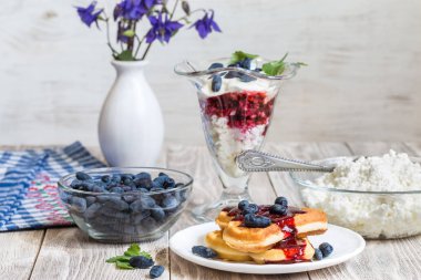 Süzme peynir, hanımeli ve waffle üzerinde masa lambası ile kahvaltı.