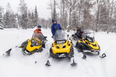 Athletes on a snowmobiles. clipart