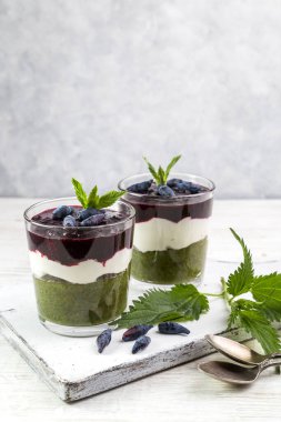 Yoğurtlu lezzetli tatlı, ısırgan otu ve hanımeli smoothie. Bardakta kaşıkla servis edilen tatlı..