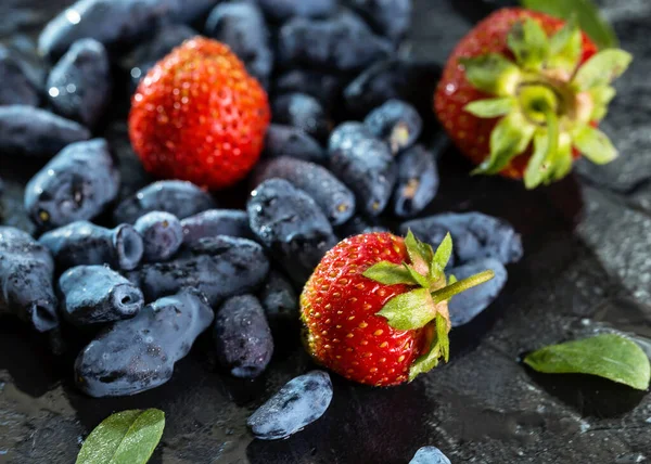 暗い背景にダークスイカズラの果実と甘いイチゴ 健康的で適切な栄養の概念 ストック画像