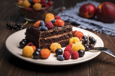 Tahta bir masada böğürtlenli çikolatalı pasta..