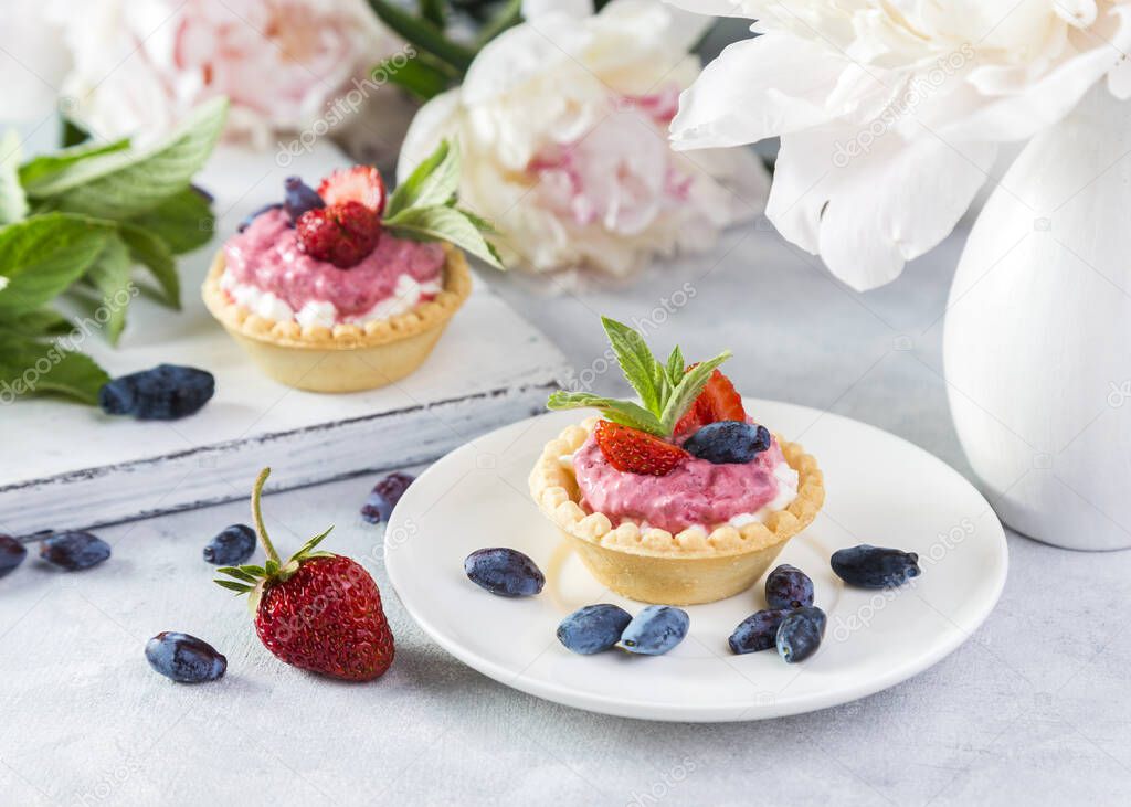 Tartlets with cottage cheese, berry yogurt, strawberries and honeysuckle.