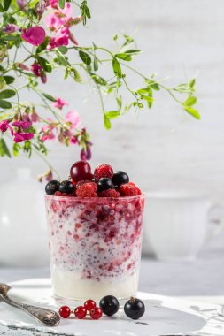 Hafif arkaplanda taze böğürtlen ve chia tohumlu yoğurt..