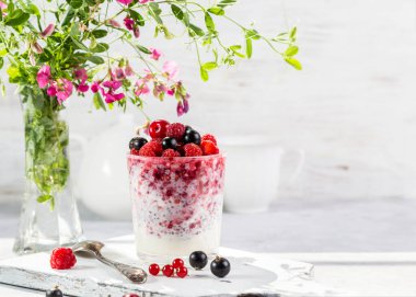 Hafif arkaplanda taze böğürtlen ve chia tohumlu yoğurt..