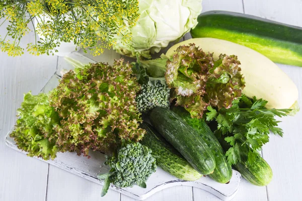 stock image Fresh green vegetables on a wooden table.