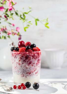 Hafif arkaplanda taze böğürtlen ve chia tohumlu yoğurt..