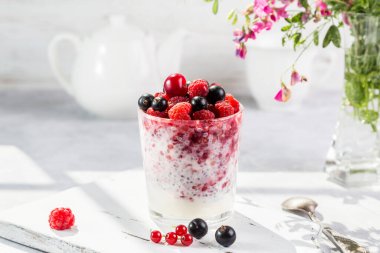 Hafif arkaplanda taze böğürtlen ve chia tohumlu yoğurt..
