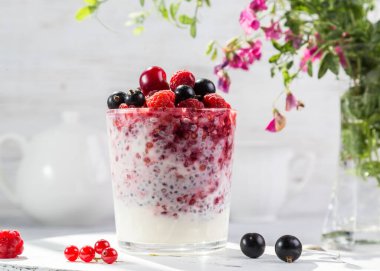 Hafif arkaplanda taze böğürtlen ve chia tohumlu yoğurt..