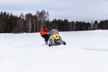 Güney Urallar 'ın dağlarındaki kış ormanlarında hareket eden bir kar aracının atleti..