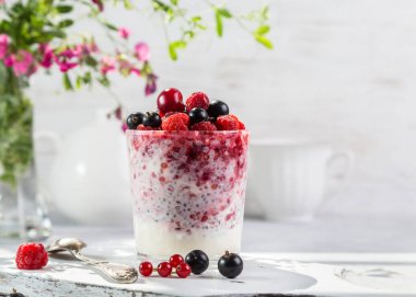Hafif arkaplanda taze böğürtlen ve chia tohumlu yoğurt..
