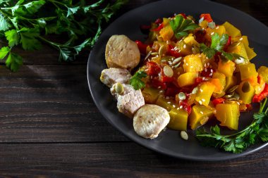 Çan biberli tavuk göğsü ve balkabağı güveci, domates, susam tohumu ve maydanozla süslenmiş kabak çekirdeği..