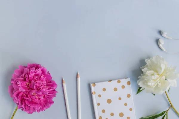 Flat lay desk with pink peony, cosmetics and accessories