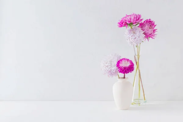 Pink flowers in a vase on a light background