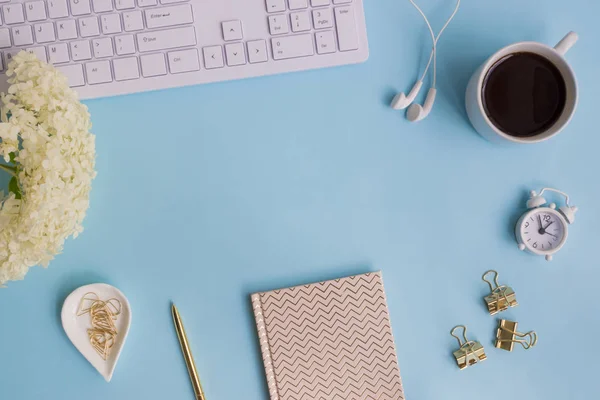 Blogger or freelancer workspace with notebook and white flower h