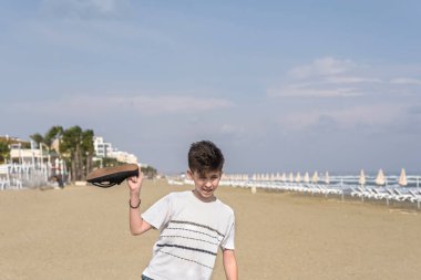  Larnaka kumlu Mackenzie plajda spor ayakkabı ile bir t-shirt çocuk. Kıbrıs adası 