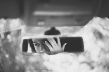 Siyah beyaz resim güzel genç kadın araba dikiz aynasında yüz. Kavram.