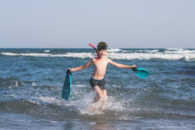 Tropik tatil kasabasında yaz tatili sırasında deniz in dalga n çalışan yüzme yüzgeçleri ve şnorkel maskesi Mutlu genç çocuk