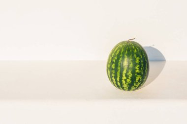 Beyaz duvar arka plan üzerinde taş banküzerinde Karpuz. Yaz konsepti