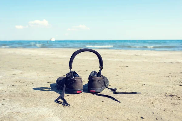 Μαύρα Sneakers Ακουστικά Στην Άμμο Στο Φόντο Της Θάλασσας Καλοκαίρι — Φωτογραφία Αρχείου
