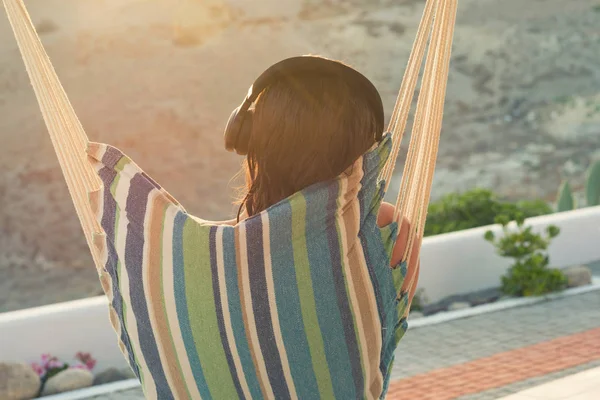 Frau Mit Kopfhörer Ruht Bei Sonnenuntergang Ihrer Villa Garten — Stockfoto