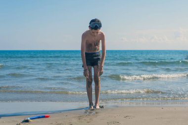 deniz arka planda sahilde şnorkel maskesi ve tüp çocuk. Spor ve sağlıklı yaşam tarzı kavramı