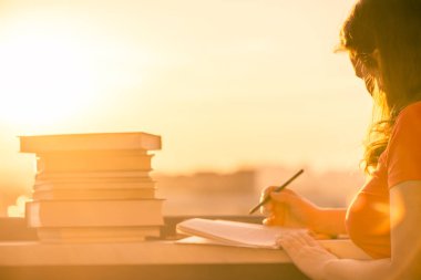 Gün batımı kasaba arka plan üzerinde üniversite sınavı için hazırlık kitapları bir sürü kız öğrenci. Eğitim kavramı