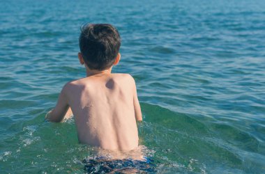 13 yaşında çocuk yüzme ve gevşeme deniz dalgaları. Aile yaz tatili kavramı