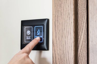 Otel odasının elektronik ekranındaki temizleme butonuna kadın parmağı basıyor. Akıllı otel odası. oda servisi 