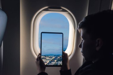 Beyaz çocuk uçak penceresinden San Francisco cityscape üzerinden fotoğraf çekmek tablet pc kullanarak. California. Abd