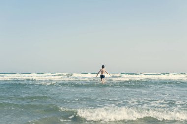Sevimli genç çocuk sahilde eğleniyor