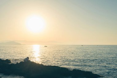 Günbatımı arka planında deniz ve kıyı manzarası 