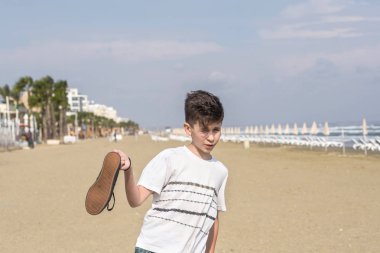  Larnaka kumlu Mackenzie plajda spor ayakkabı ile bir t-shirt çocuk. Kıbrıs adası 