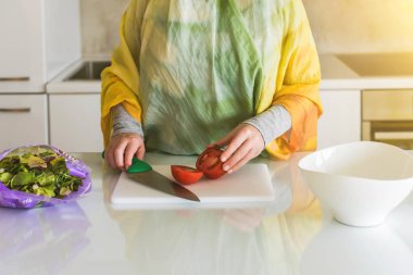 Müslüman kadın mutfakta domates doğrama . Salata hazırlama