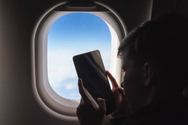 Kafkas çocuk emniyet kemeri sabitleyin ve Tablet PC kullanarak ve hava uçuş sırasında resim çekerken. Çocukla güvenlik seyahati. Kavram 