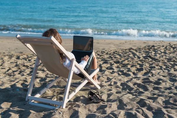 화창한 바다의 배경에 해변에서 노트북과 사무실 — 스톡 사진