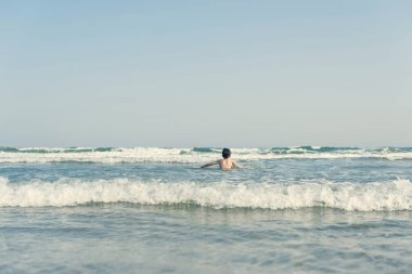 Sevimli genç çocuk sahilde eğleniyor