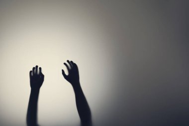 Cam kapının arkasında kadın ellerinin koyu silueti. Depresyon, korku, panik atak kavramı