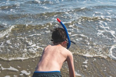 Denizde rahatlatıcı maskeli genç çocuk