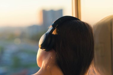Günbatımında şehir içinde müzik dinlemek kulaklık kız 