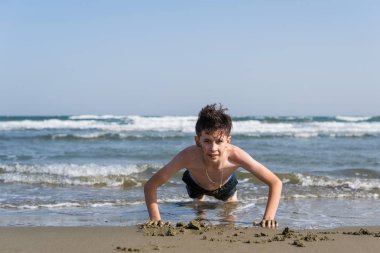çocuk deniz arka plan üzerinde sahilde kumüzerinde dışarı wred. Spor ve sağlıklı yaşam tarzı kavramı