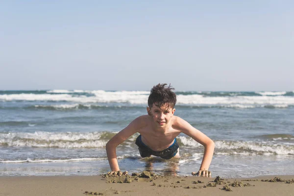 Ragazzo Strizzato Sulla Sabbia Sulla Spiaggia Sullo Sfondo Del Mare — Foto Stock