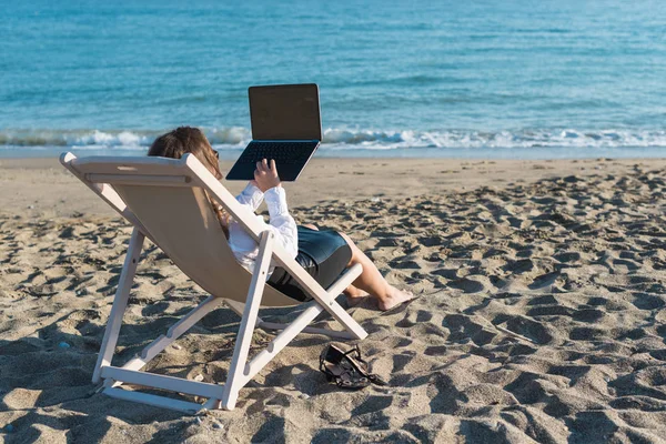 화창한 바다의 배경에 해변에서 노트북과 사무실 — 스톡 사진