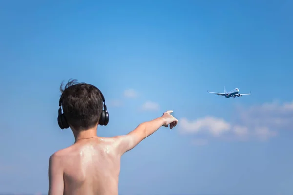 Teen boy in the headphones on beach. Traveling with child. Concept