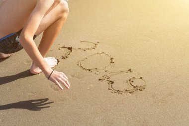 Yüzme Trunks çocuk yeni yıl ve yılbaşı için plajda kum üzerinde yazıt 2019 yazma. Kavram 