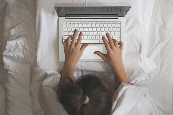 담요로 침대에 노트북과 여자는 일해야 합니다 — 스톡 사진
